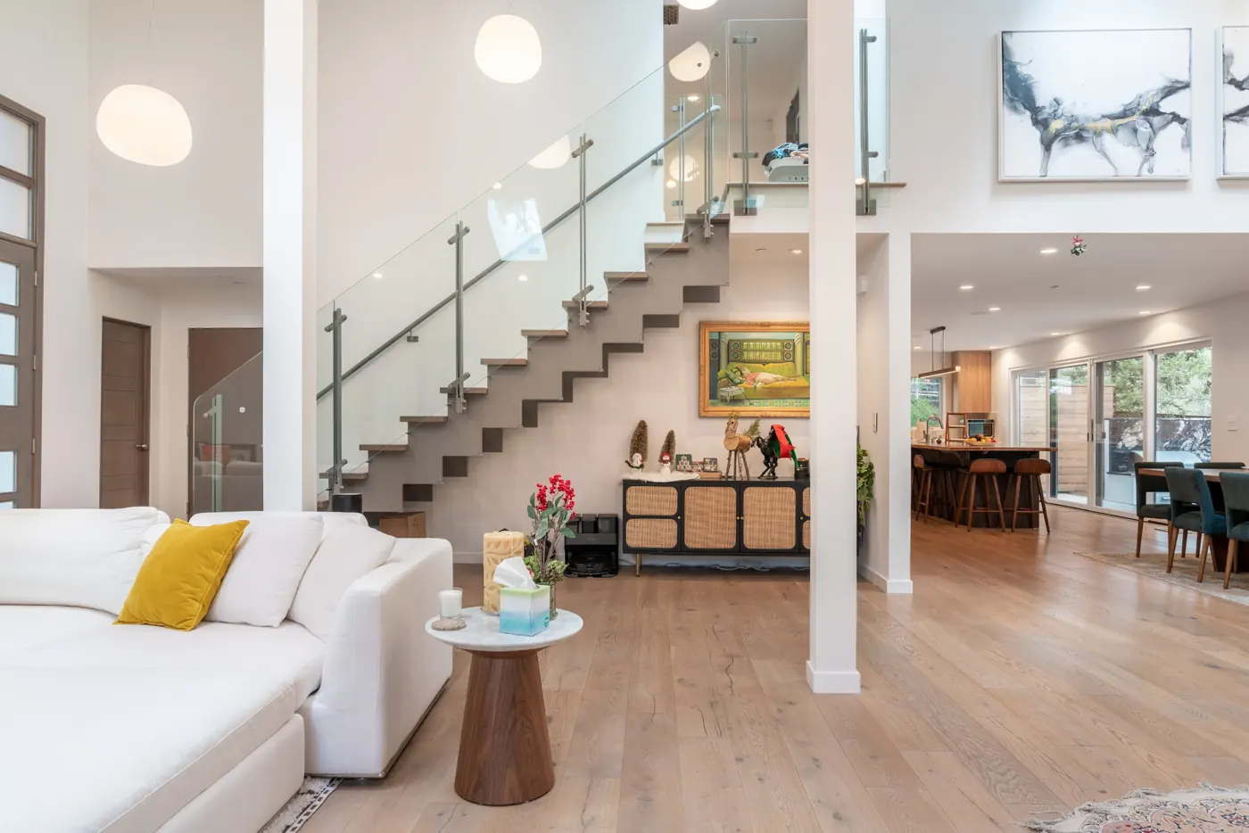 Whole-home renovation with open living space, floating staircase and glass railings