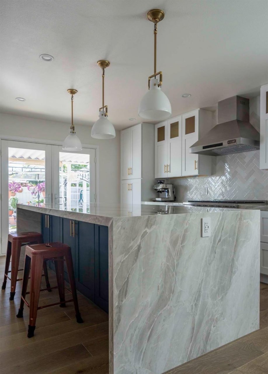 Waterfall marble island with bar seating and pendant lights by Lussoro Design + Build
