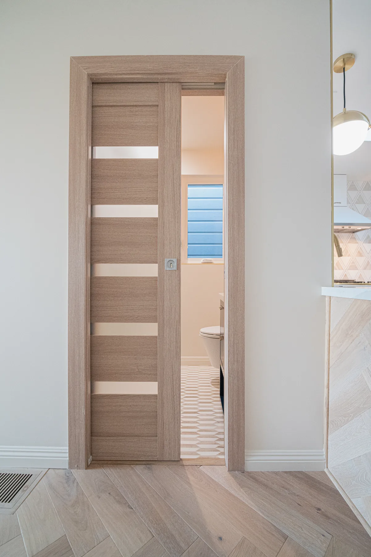Modern bathroom renovation with wood interior door by Lussoro Design + Build