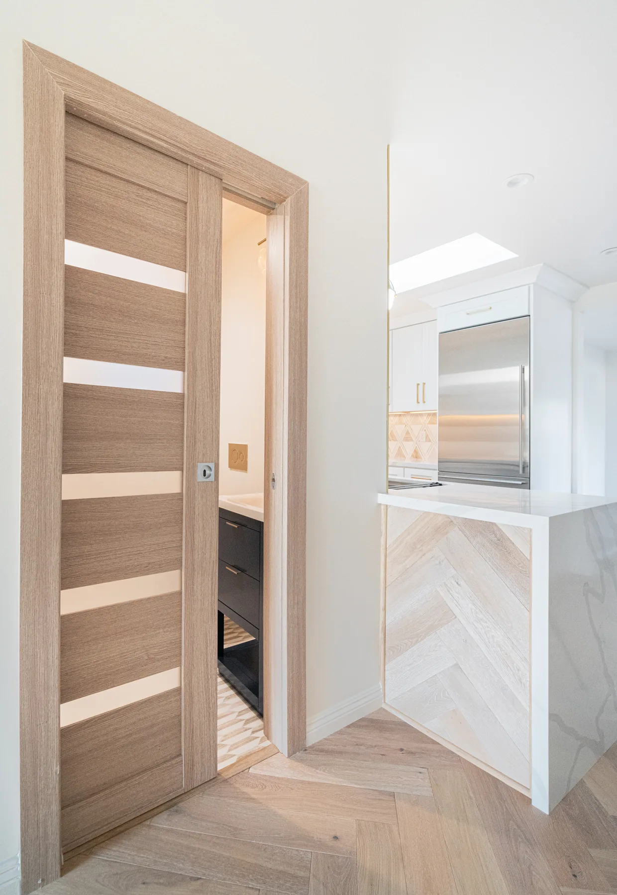 Renovated bathroom and kitchen interior with modern wood doors by Lussoro Design + Build