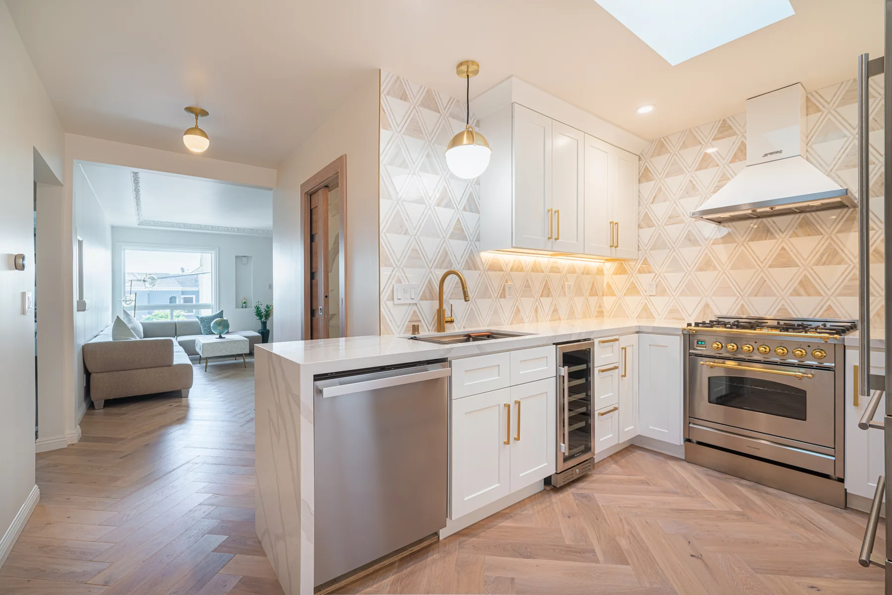 White kitchen remodel with island, stainless appliances and brass accents by Lussoro Design + Build
